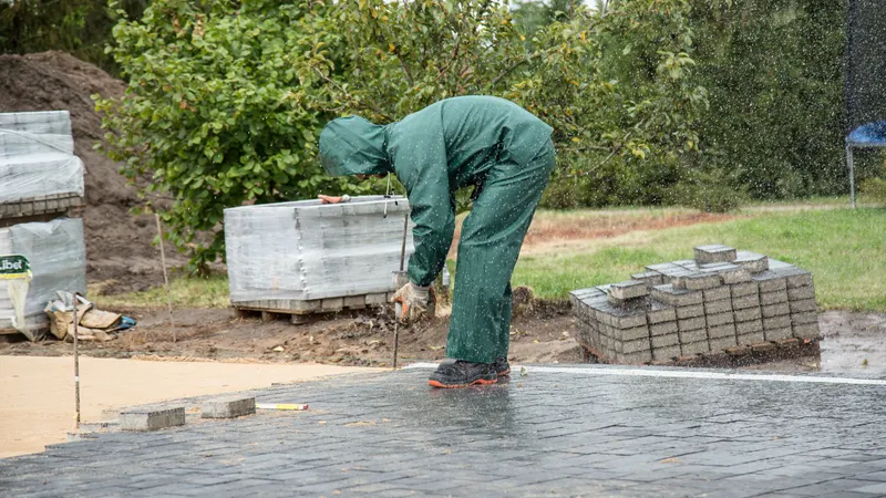 Radnik polaže betonske opločnike na pripremljenu podlogu